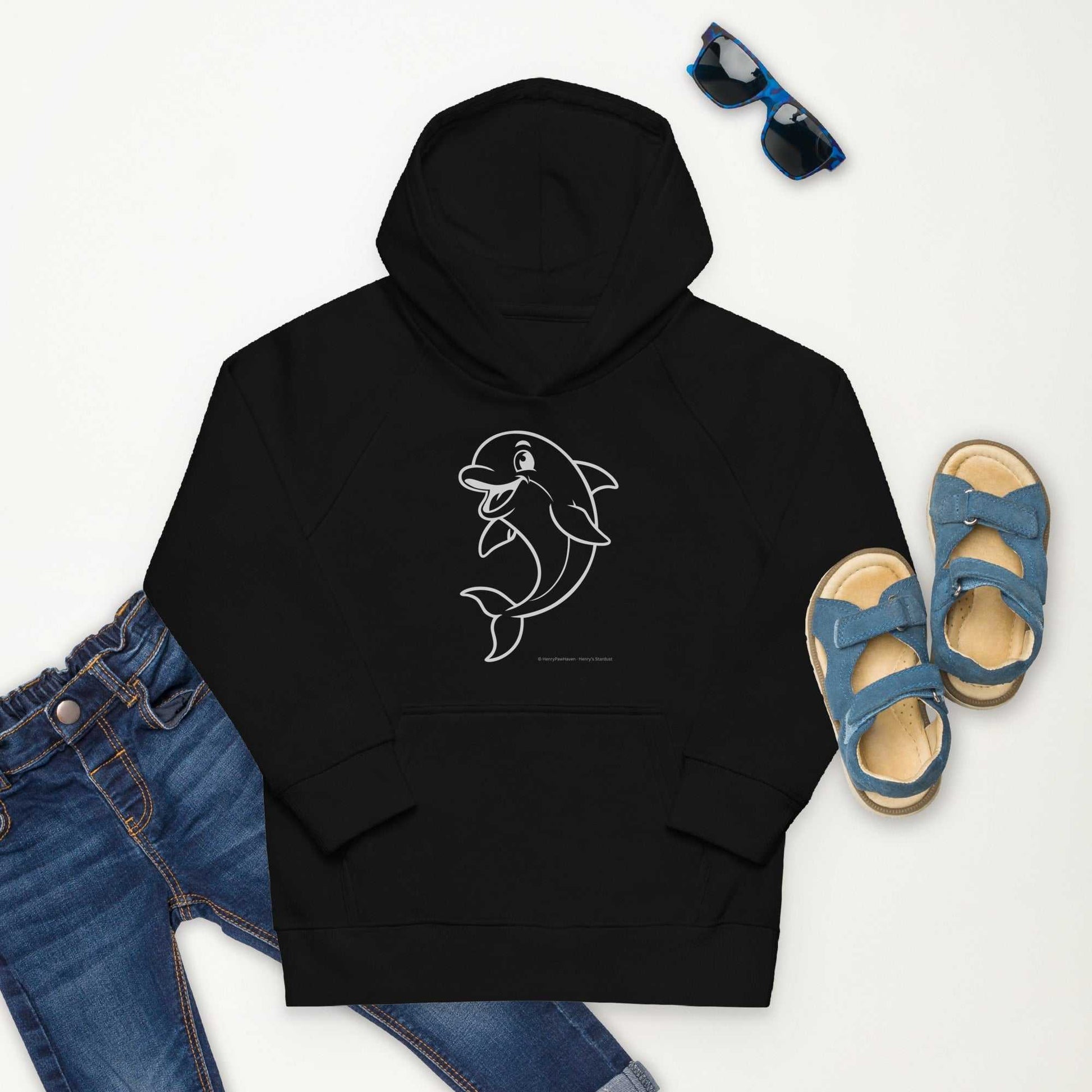 Flat lay of black Kids Eco Hoodie Dolphin with dolphin print, paired with jeans, sandals, and sunglasses. Organic cotton and recycled polyester.