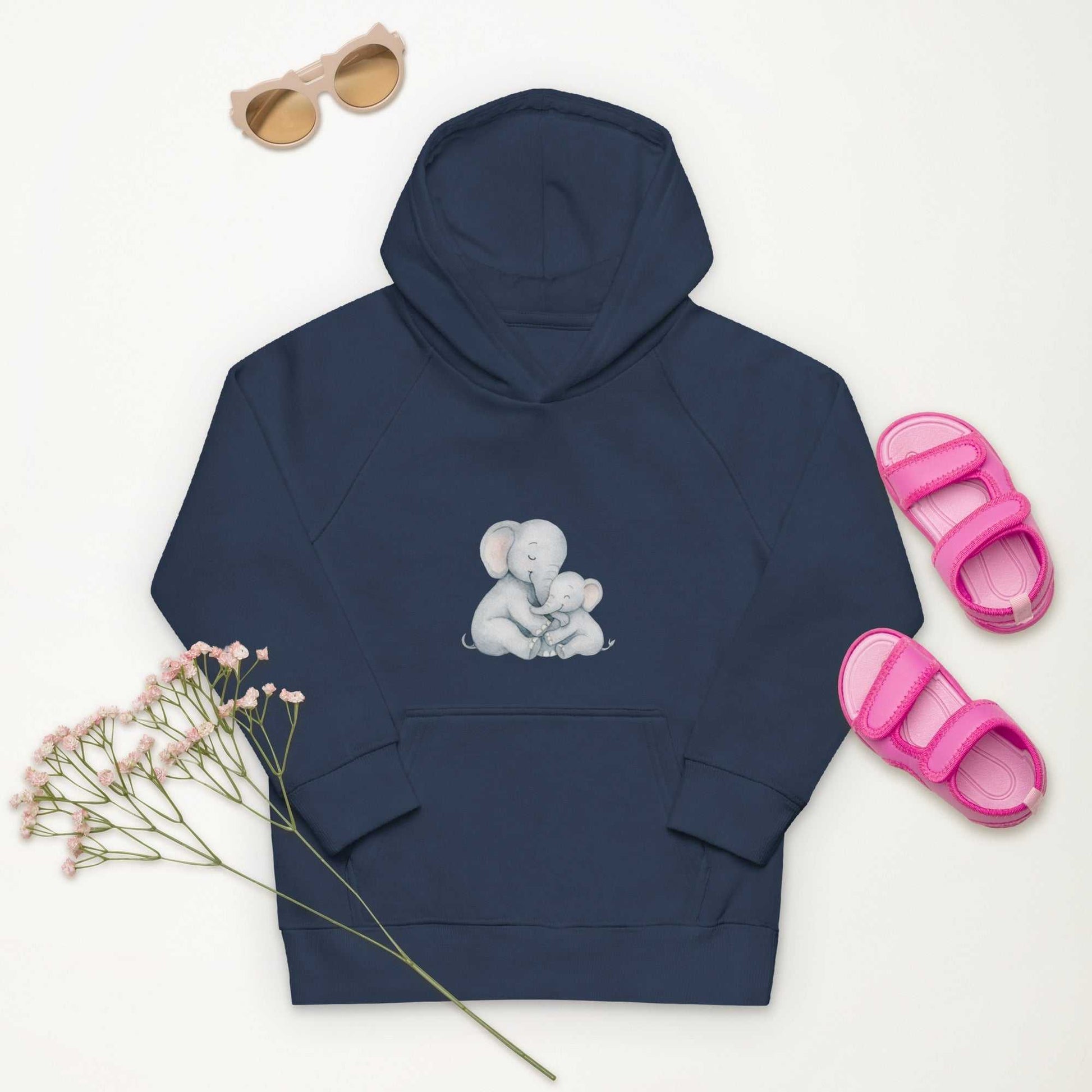 Navy Kids Eco Hoodie featuring a cute Mom & Baby Elephant print, laid flat with pink sandals and sunglasses for a playful outfit idea.