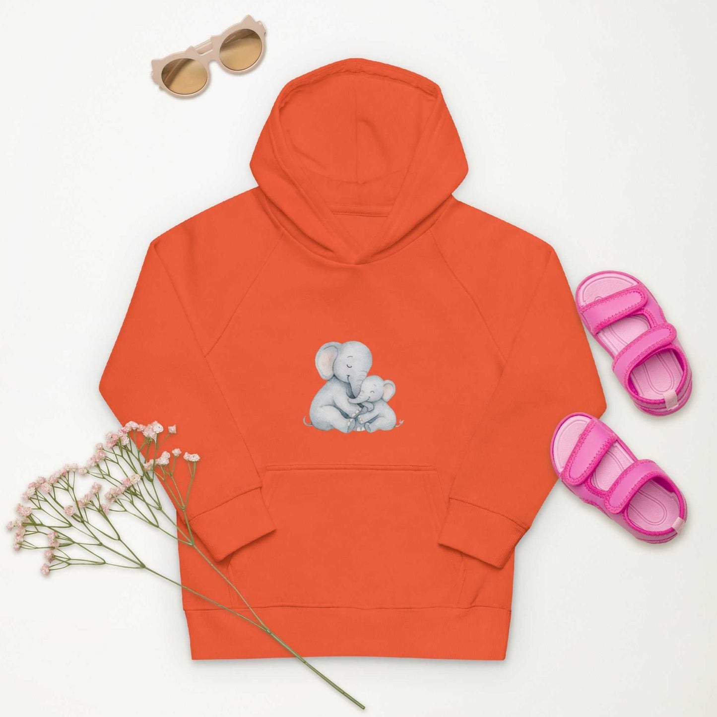 Orange Kids Eco Hoodie with adorable Mom & Baby Elephant design, styled with pink sandals and sunglasses for a vibrant kidswear look.