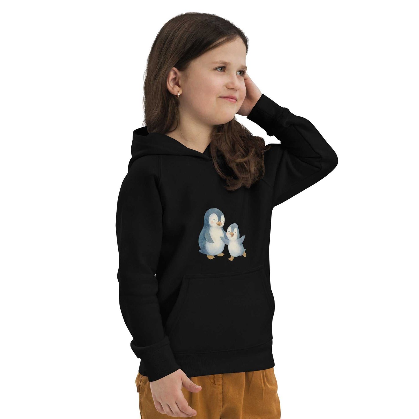 Girl wearing black organic cotton hoodie with penguin print, soft and sustainable clothing for everyday adventures.