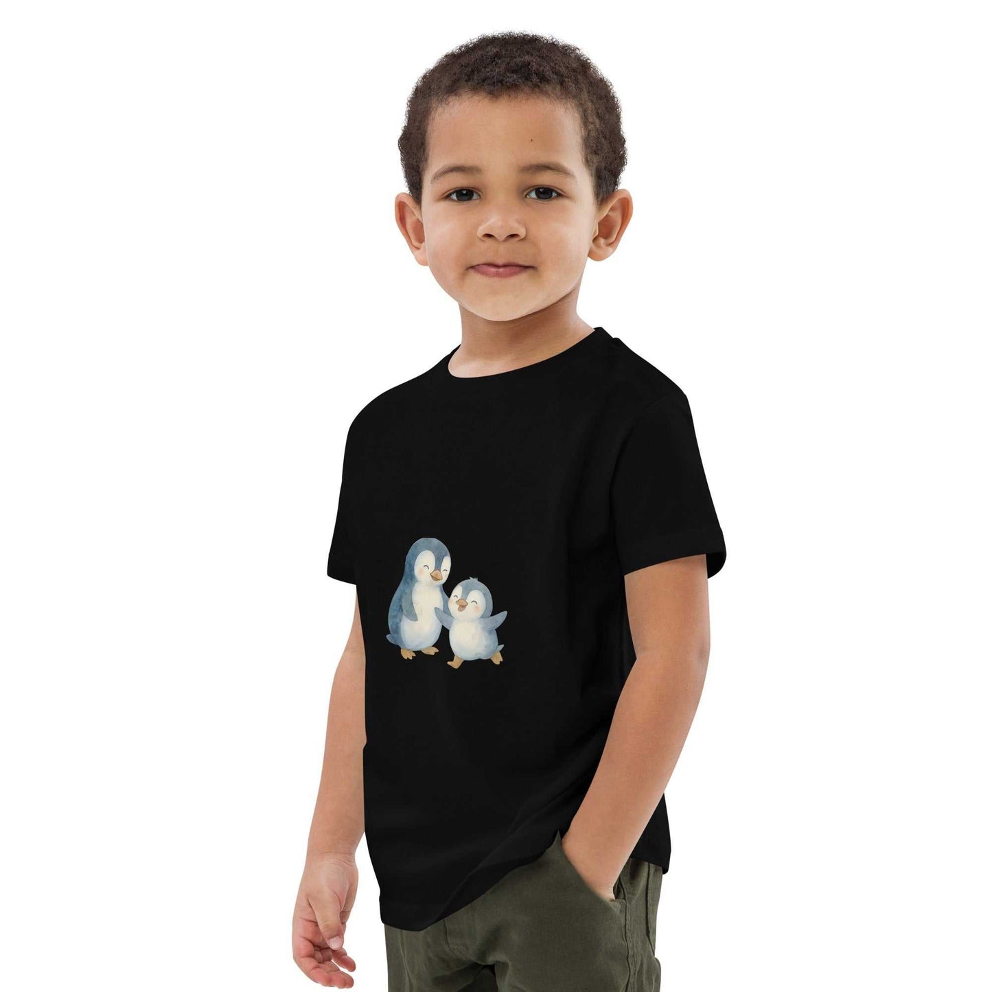 Boy modeling black kids organic cotton penguin t-shirt with adorable penguin print. GOTS certified and eco-conscious apparel.