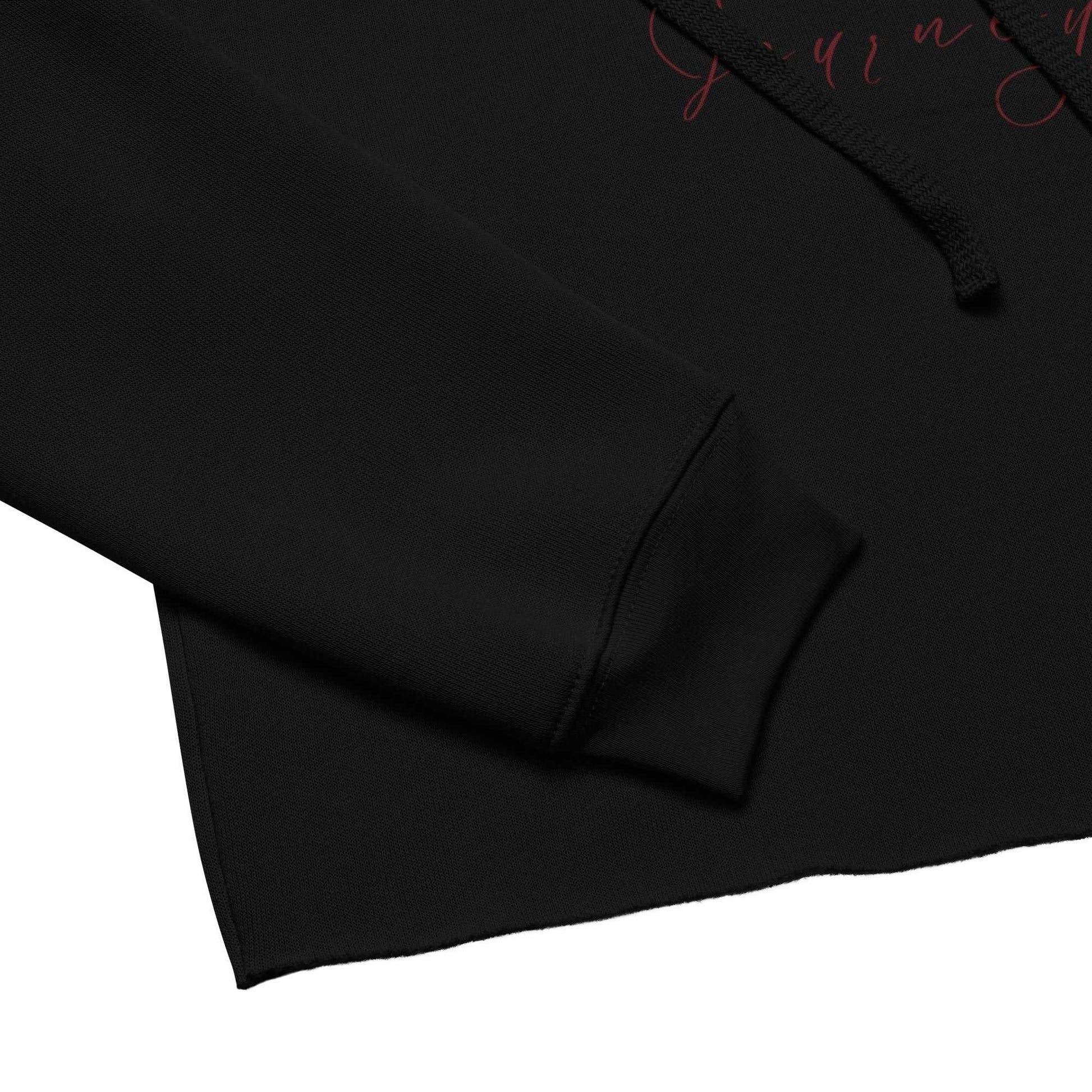 Close-up of black cropped hoodie sleeve and hem showing soft airlume cotton blend and raw edge finish for a trendy look.