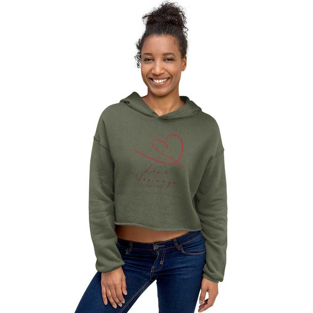 Model wearing olive green cropped hoodie with red heart and 'Love Journeys' design. Feminine and cozy for daily wear.