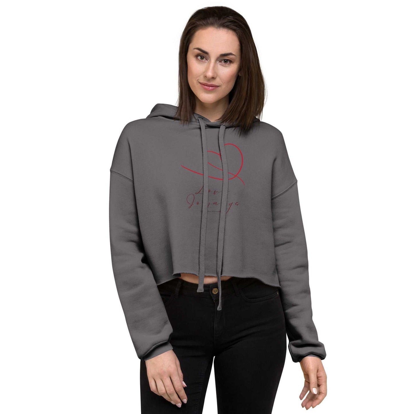 Model wearing grey womens cropped hoodie love design with red heart and text. Stylish cropped cut and soft fabric for a romantic casual look.