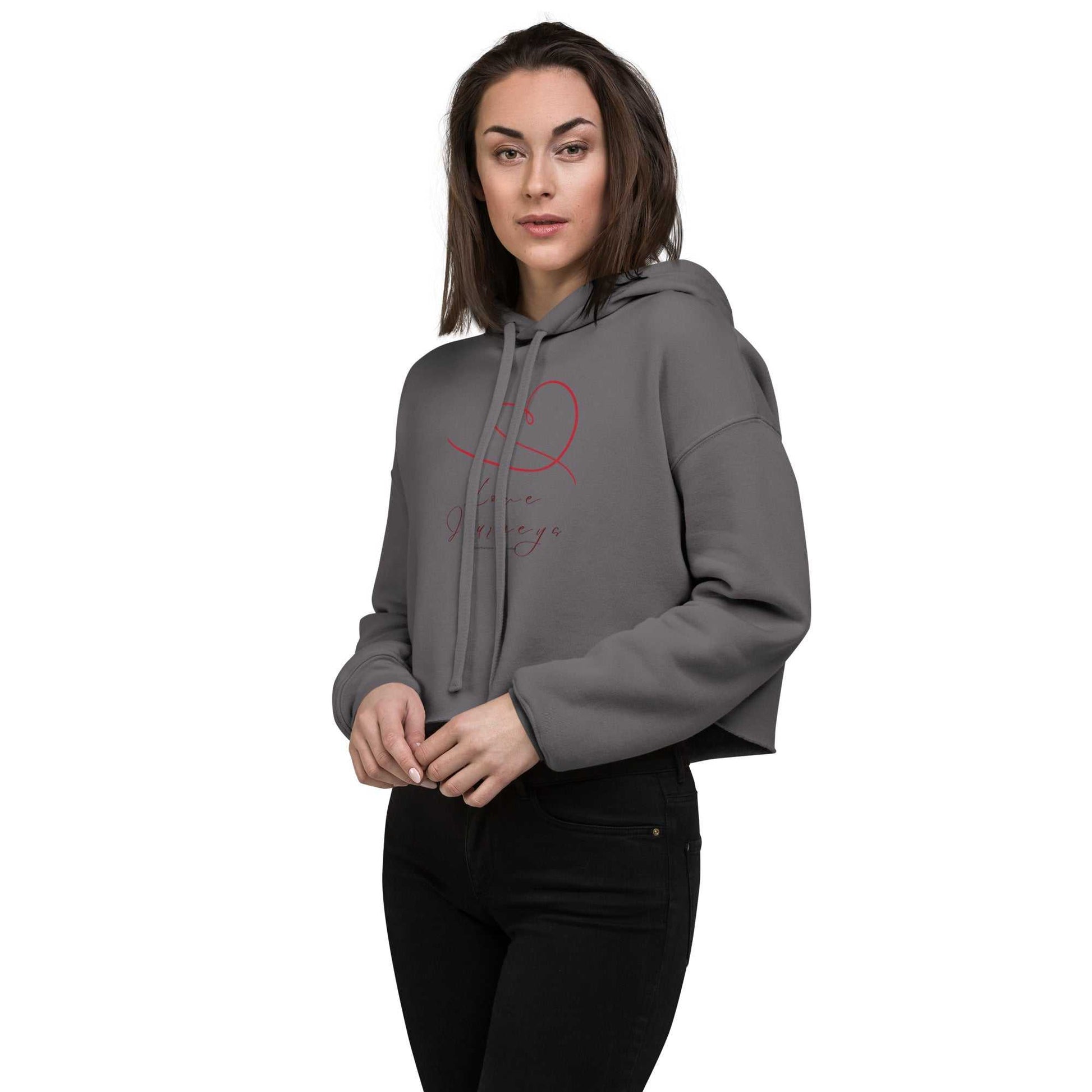 Front view of model in grey cropped hoodie with love design. Red heart and script add a sweet touch to this trendy activewear top.