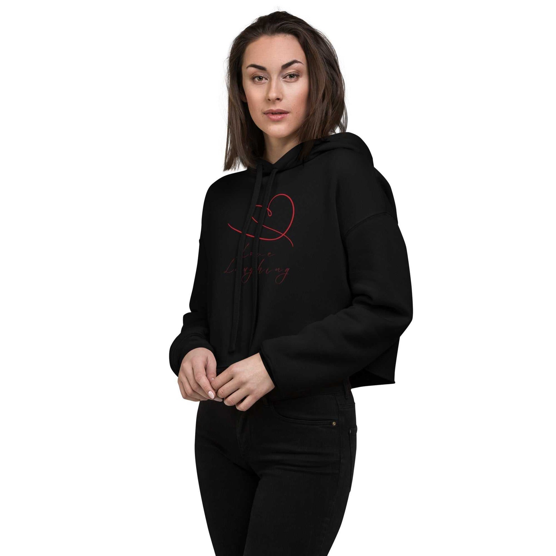 Front view of model in black Love Laughing Women's Cropped Hoodie, featuring red heart Valentine's design and relaxed fit.