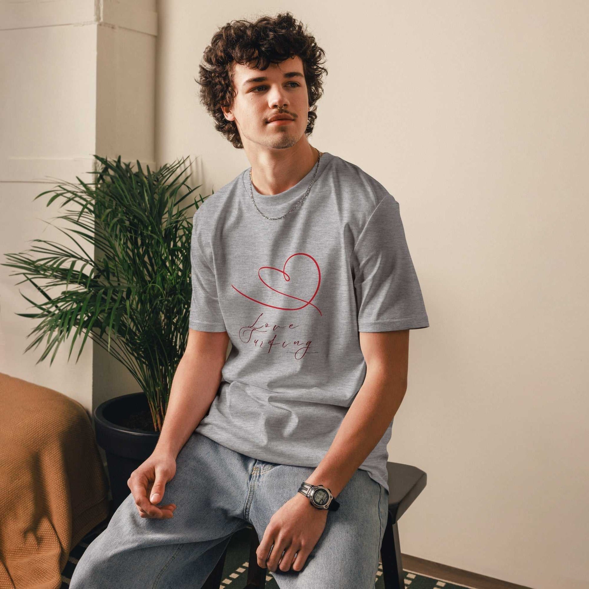 Man wearing Love Surfing T-Shirt in grey, made from organic cotton. Ethical apparel with red heart and cursive text design.