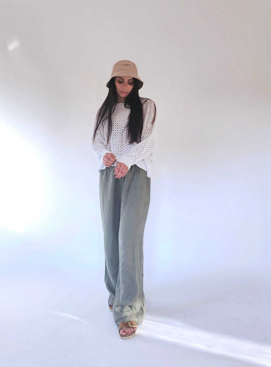 Open-Knit Cotton Sweater - Fabiana by Tenné in white, styled with olive green wide-leg pants and a beige bucket hat. Eco-friendly, breathable design.