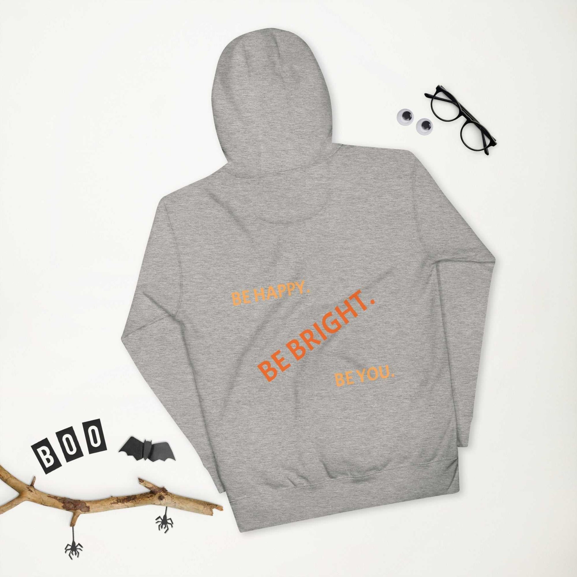 Heather gray premium unisex hoodie laid flat showing 'Be Happy. Be Bright. Be You.' text, ideal for cozy seasonal wear.