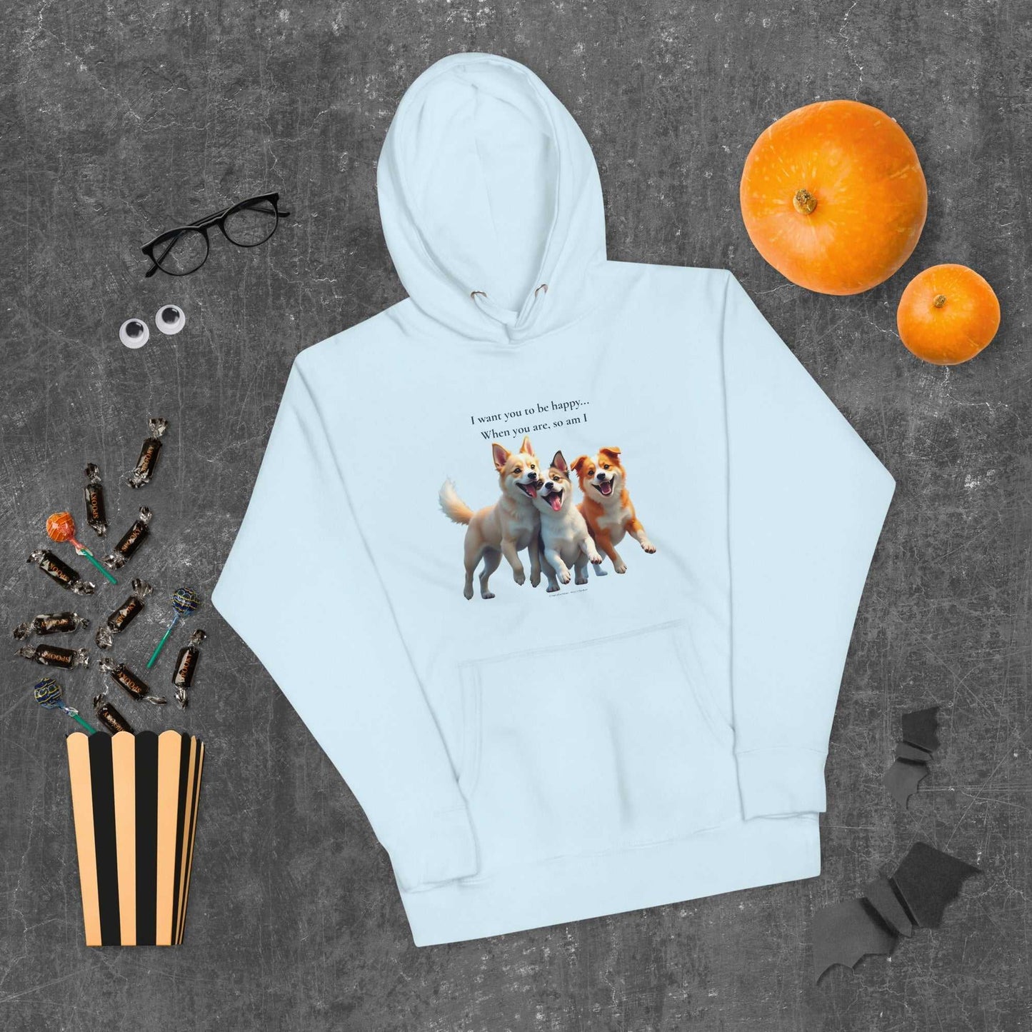 Light blue unisex hoodie for comfort with dog trio design, styled flat with pumpkins and candy for festive activewear look.