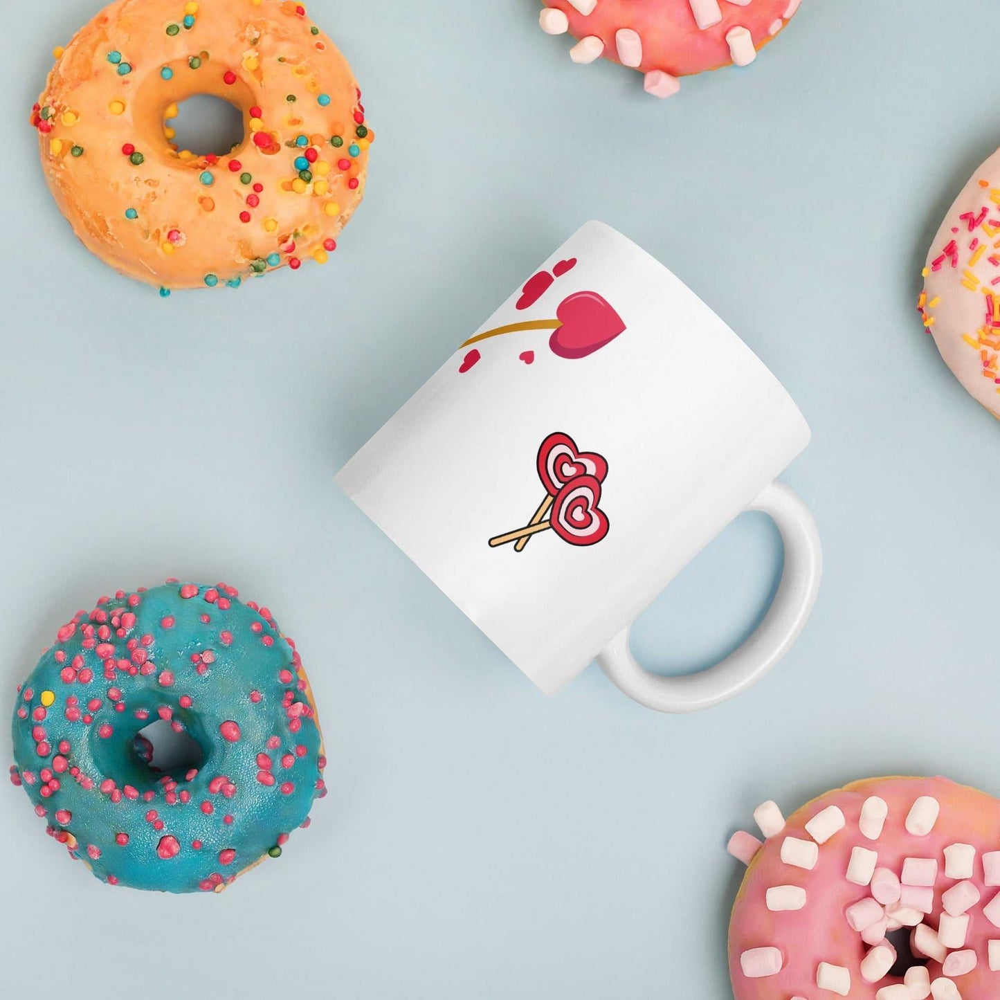 Valentine mug gift with heart lollipops and arrow design surrounded by donuts, fun and festive romantic drinkware.