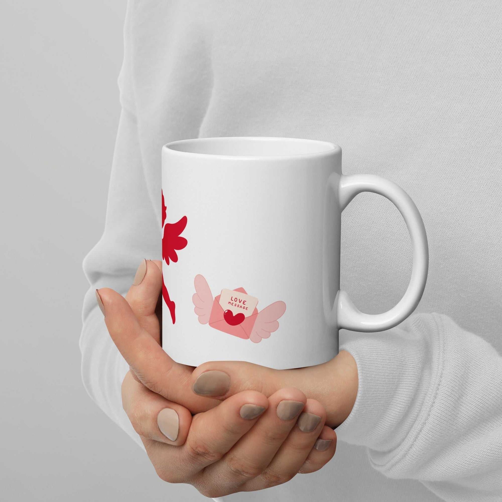 Person holding Valentine Mug - Cupid & Butterfly gift showing pink butterfly and love letter. Ceramic 11 oz mug ideal for Valentine's Day.