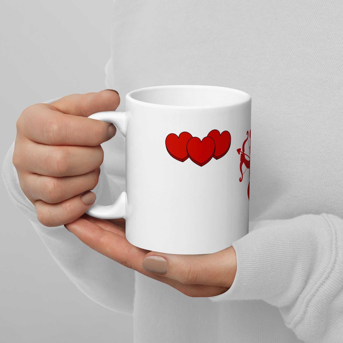 Person holding Valentine Mug - Cupid & Butterfly gift with red hearts and cupid. 11 oz ceramic mug for romantic kitchen and dining use.