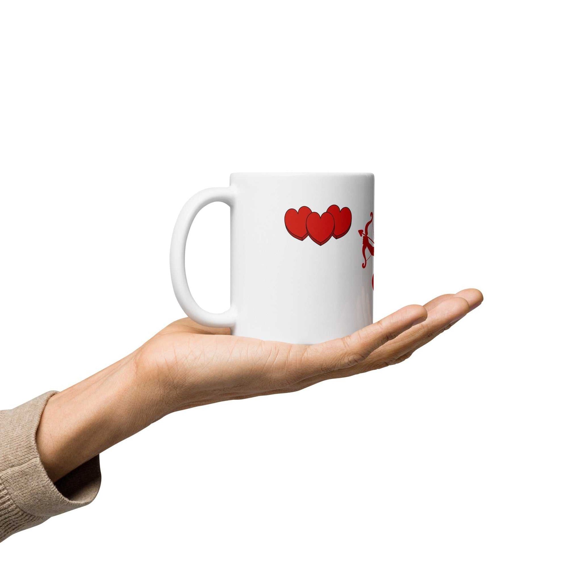 Hand holding Valentine Mug - Cupid & Butterfly gift showing red hearts and cupid. Ceramic 11 oz drinkware for Valentine's Day celebrations.