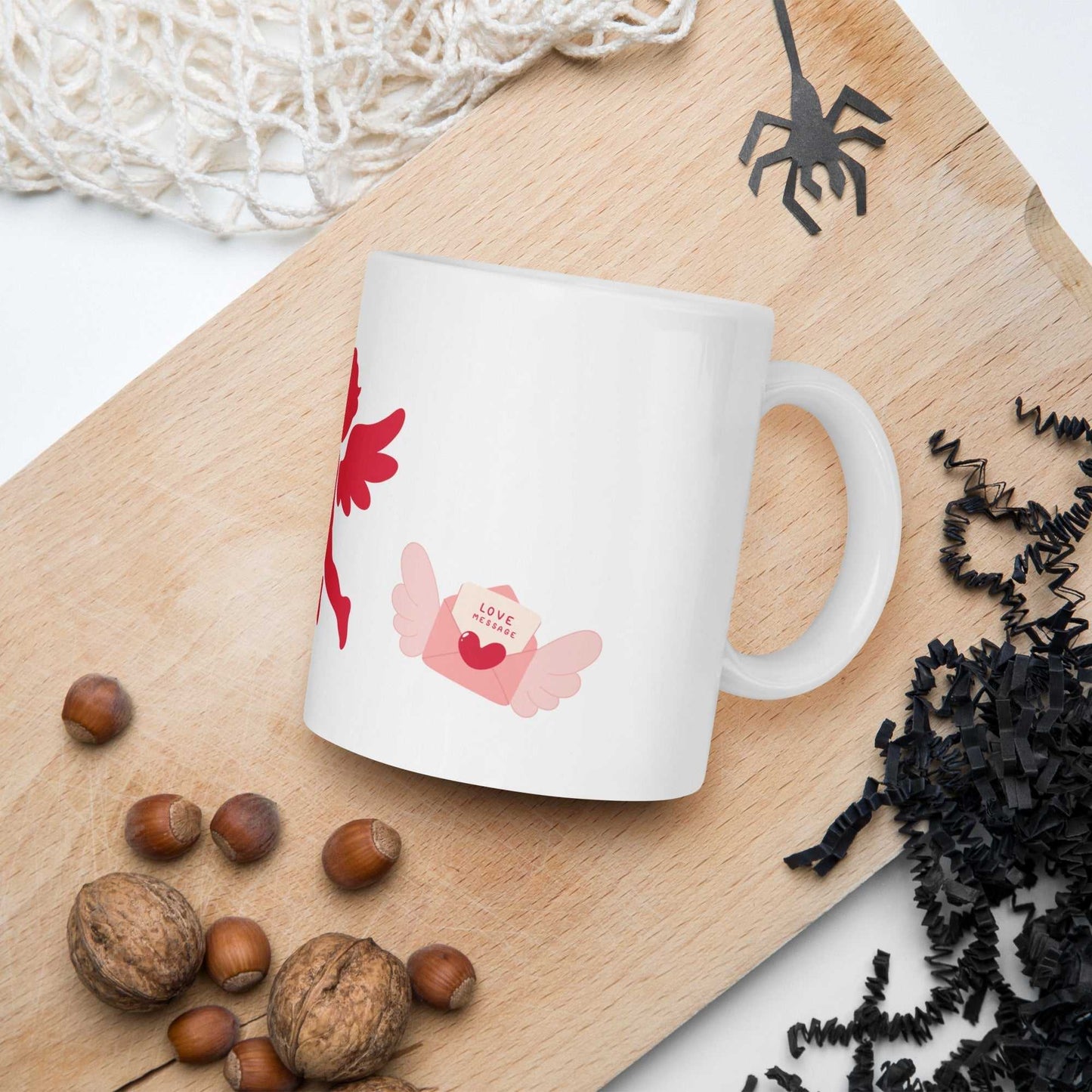 Valentine Mug - Cupid & Butterfly with winged love letter, ceramic 11 oz mug placed on rustic wooden board with nuts.