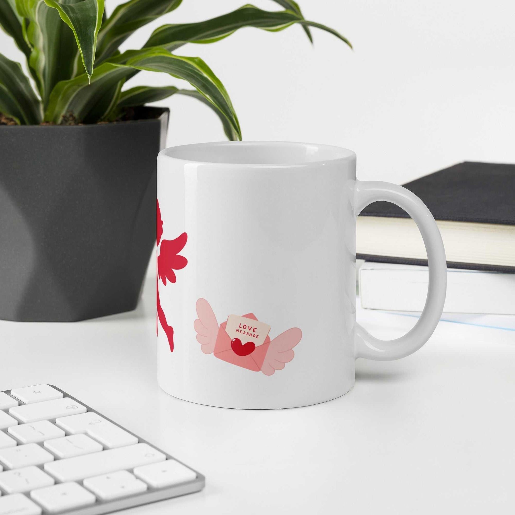 Valentine Mug - Cupid & Butterfly with love letter graphic, ceramic 11 oz mug styled on office desk for gifting or personal use.