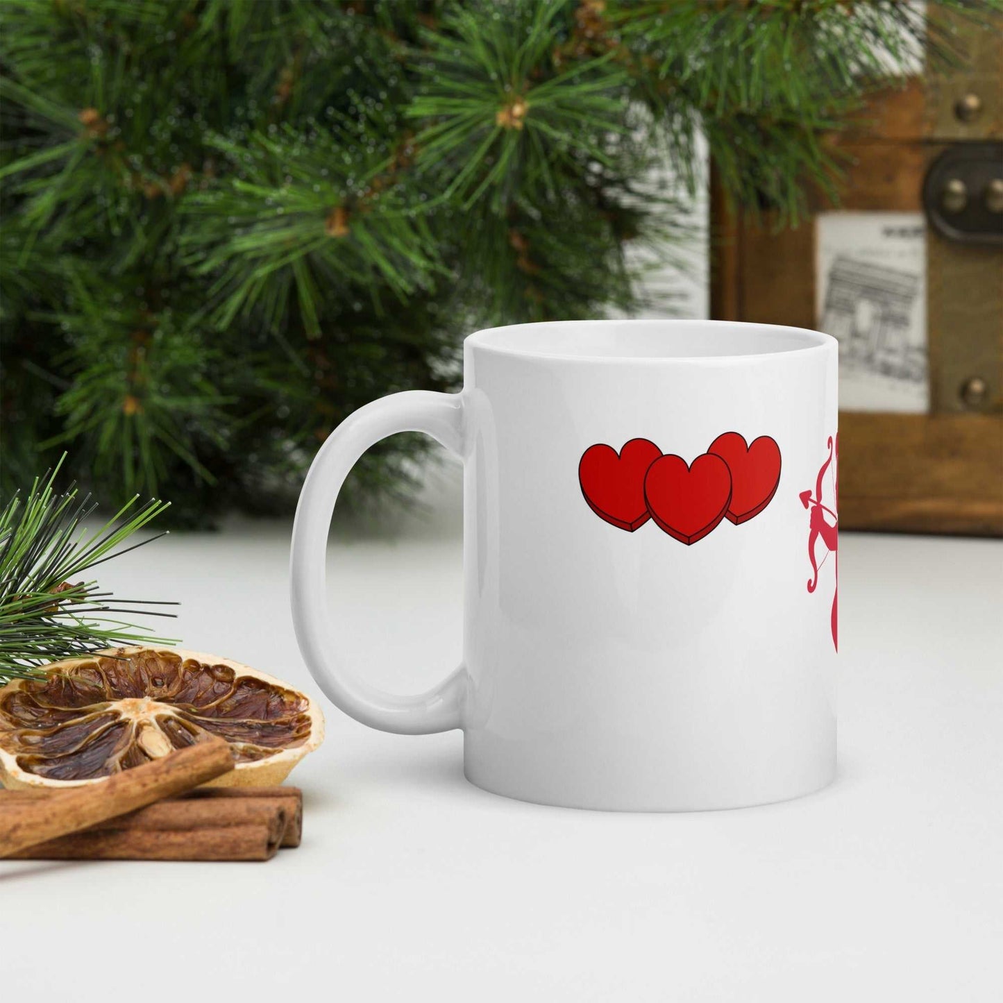 Valentine Mug - Cupid & Butterfly with red heart trio, 11 oz ceramic mug styled with cinnamon and pine for seasonal gifting.