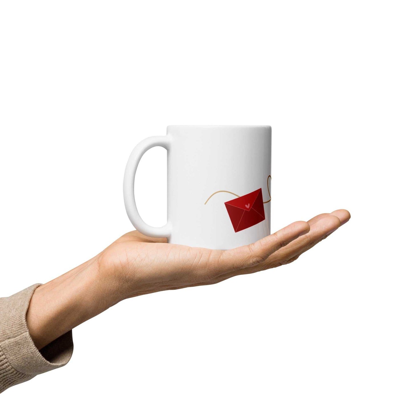 Hand presenting ceramic valentine mug with red envelope design, part of Envelope & Hearts gift collection, 11 oz size.