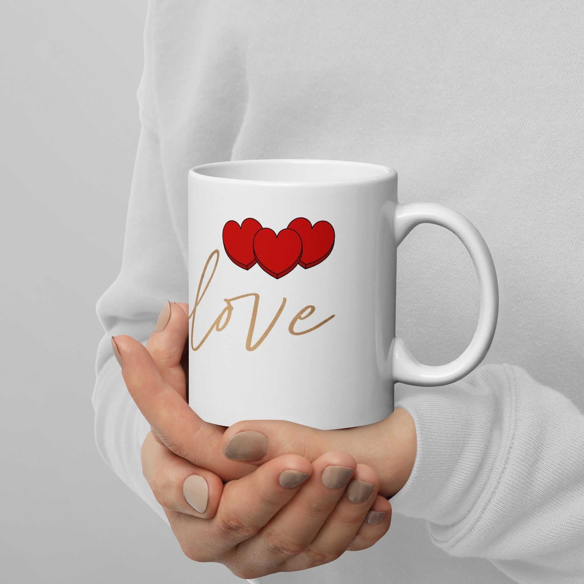 Valentine Mug - Envelope & Hearts held in hands, featuring red hearts and 'love' script, ceramic and dishwasher safe.
