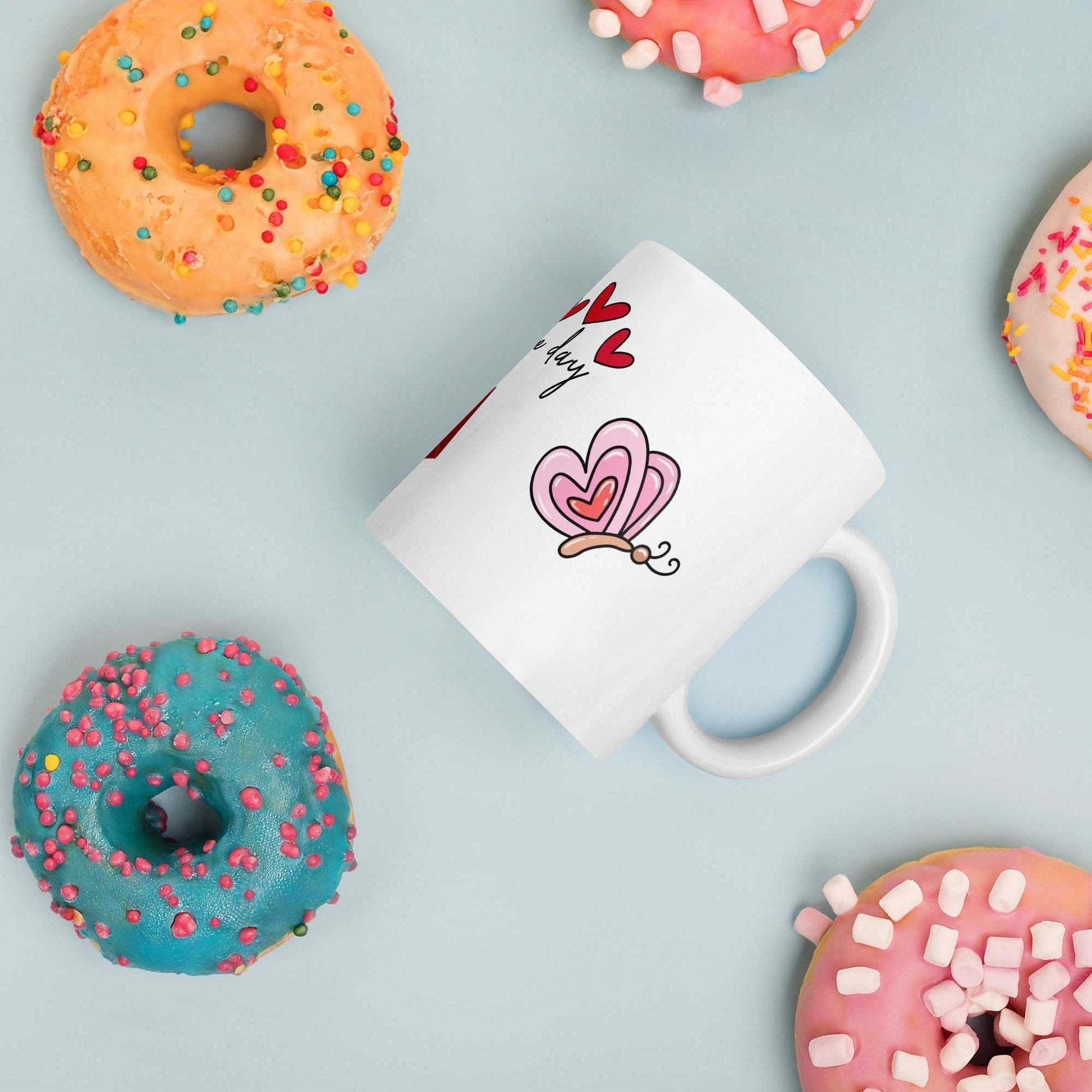 Valentine Mug - Ceramic Hearts Gift with butterfly design, styled with colorful donuts for a festive breakfast setting.