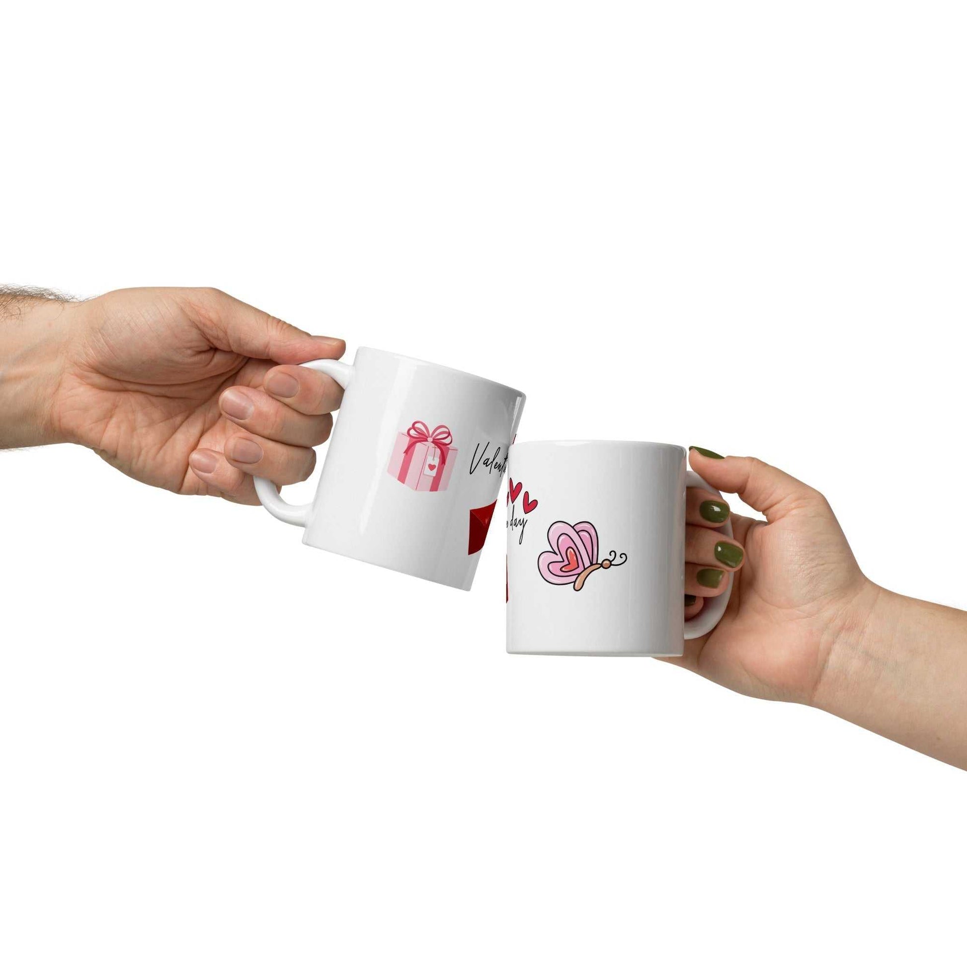 Two people clinking Valentine mugs with heart and butterfly designs, symbolizing love and celebration.