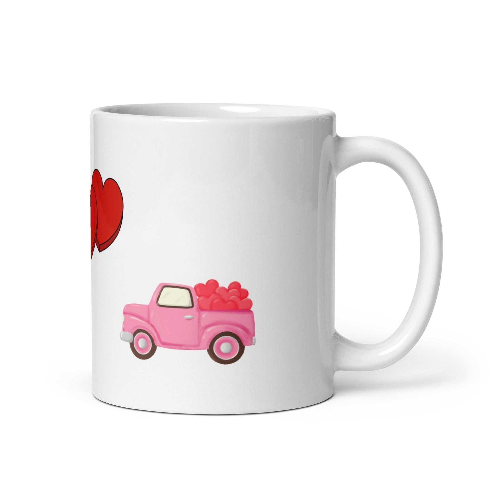 White ceramic Valentine mug featuring a pink truck carrying red hearts, part of a romantic 'Be Mine' themed design.