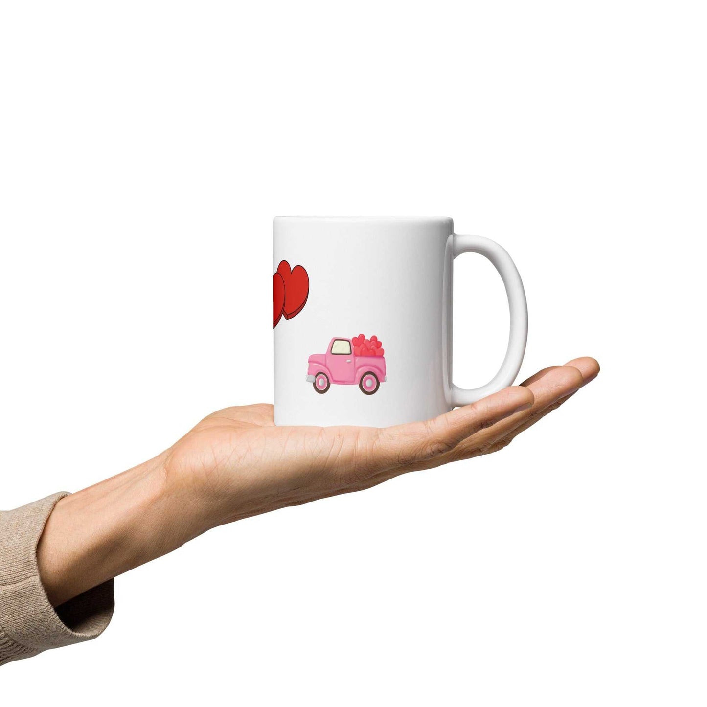 Valentine mug with pink truck and heart design held in hand, perfect for gifting or cozy coffee moments.