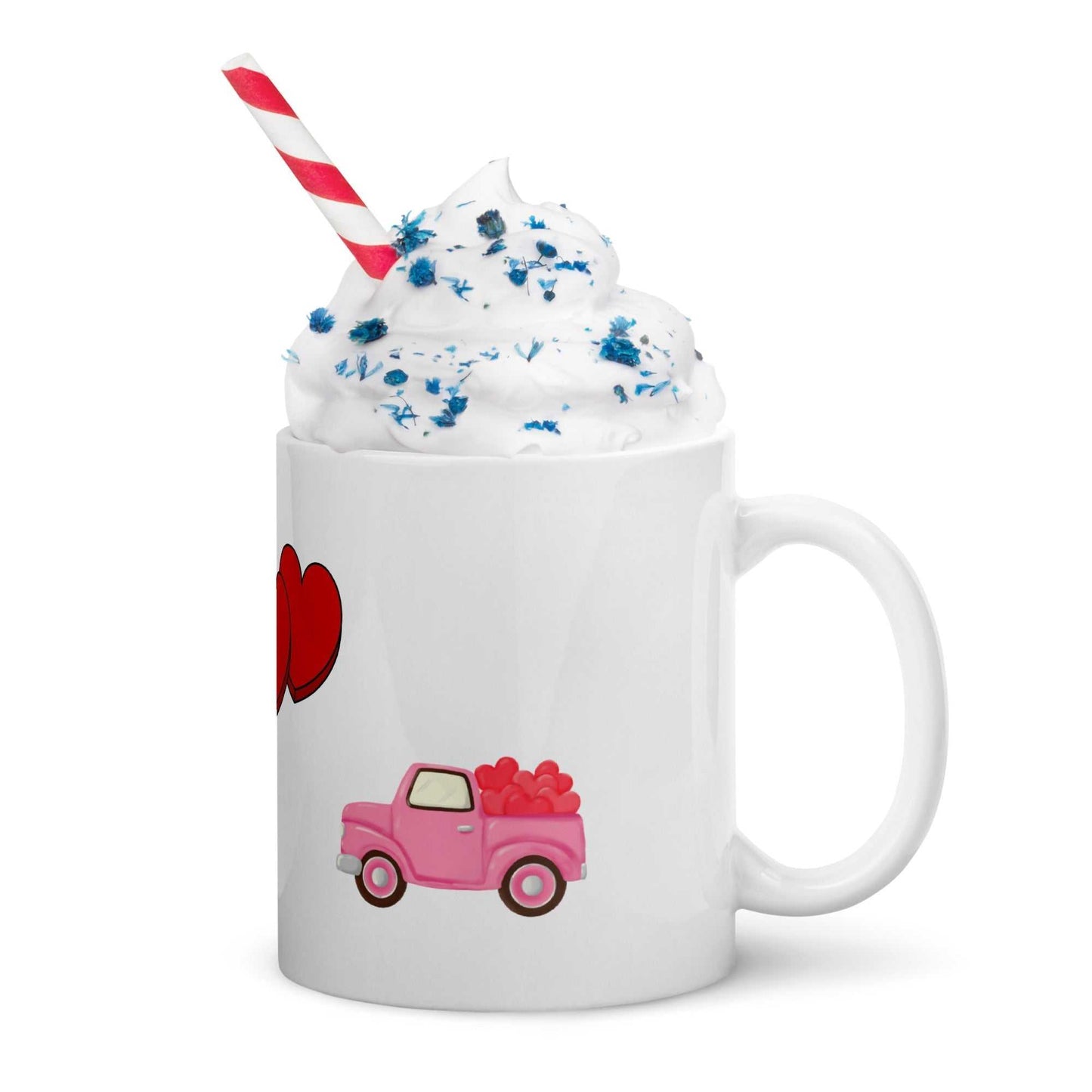 Ceramic Valentine mug with pink truck and hearts, topped with whipped cream and straw, perfect for romantic beverages.