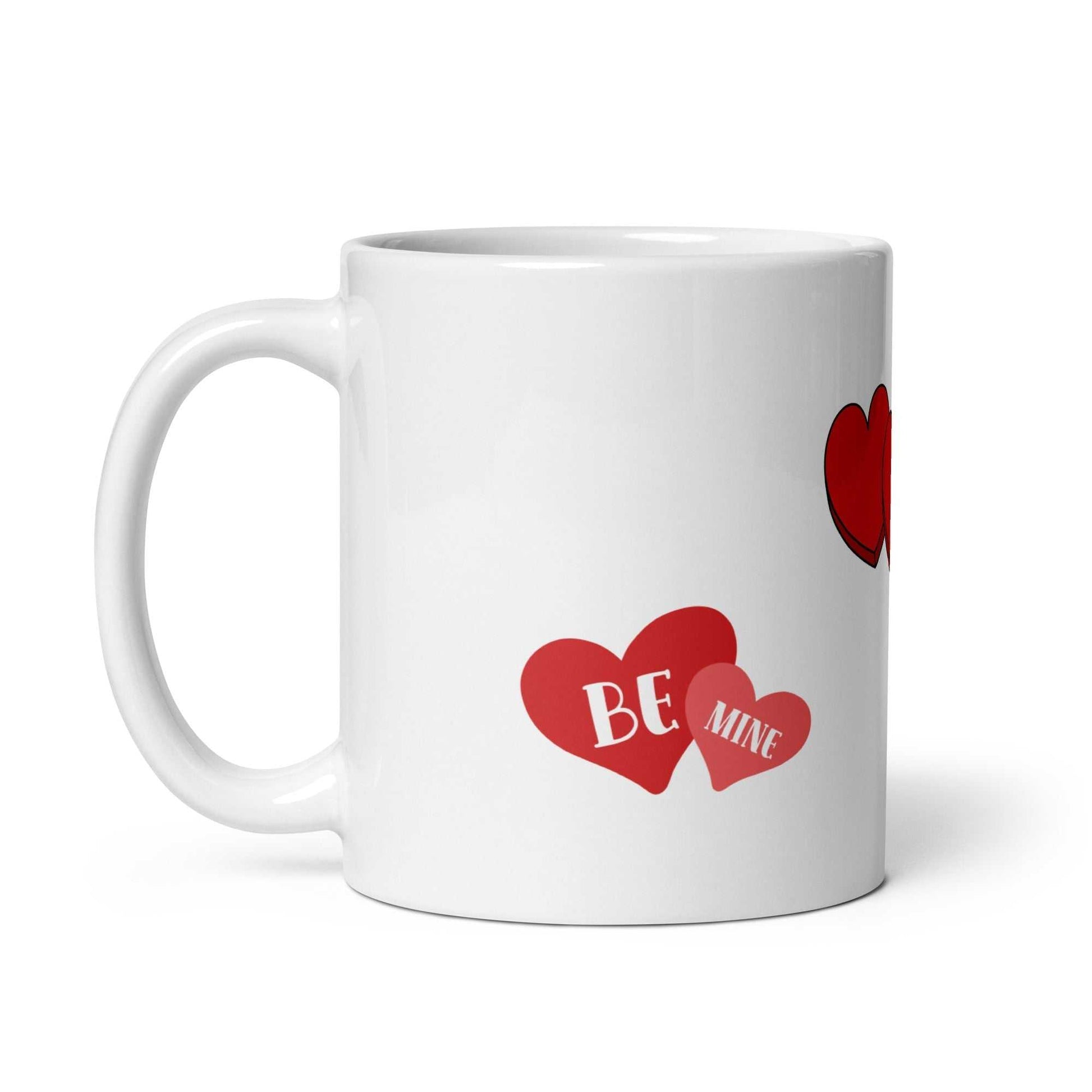 Close-up of 11 oz ceramic Valentine mug with overlapping red hearts and 'Be Mine' text, perfect for Valentine's Day gifts.