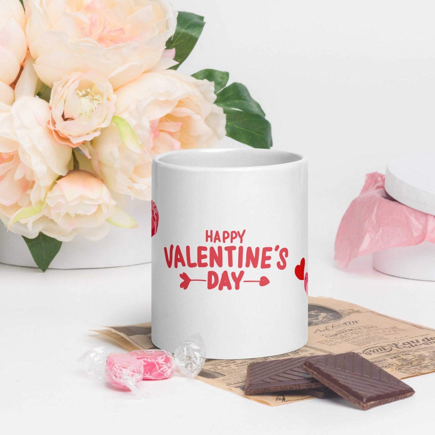 Happy Valentine's Day mug with red text and hearts, styled with chocolates and floral décor; perfect for gifting.