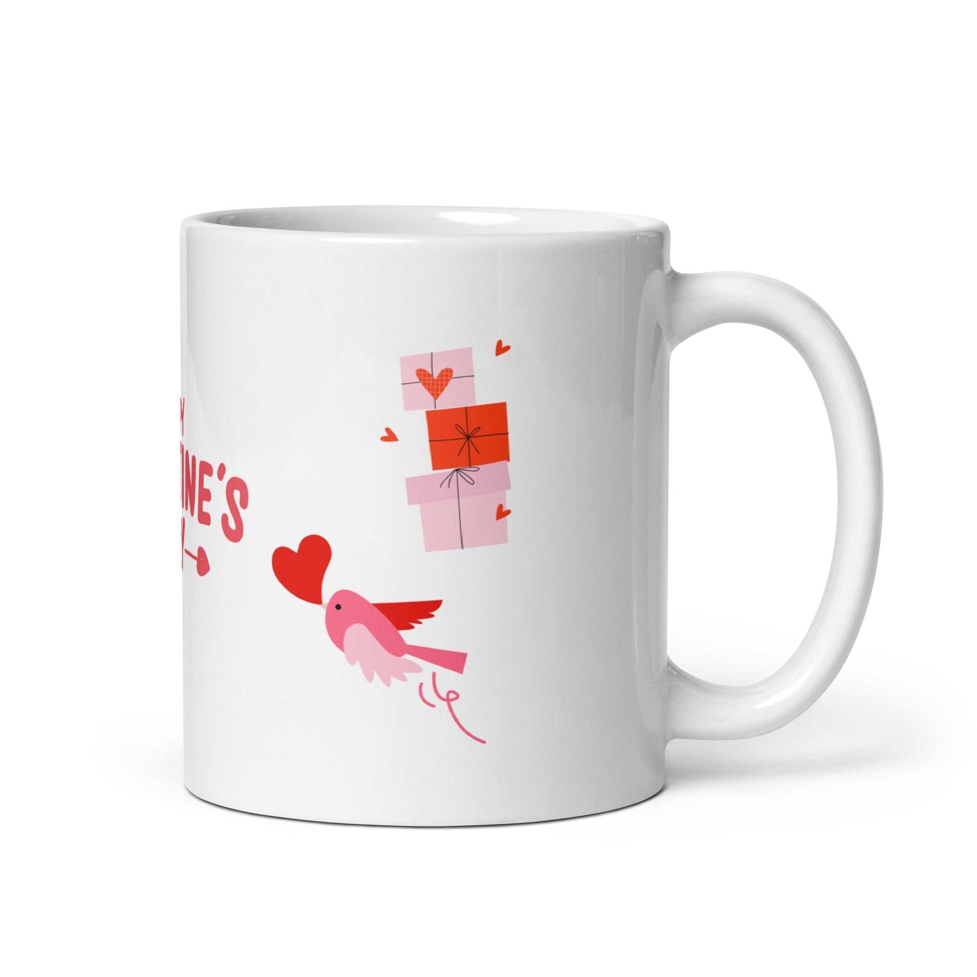 Ceramic valentine mug featuring a pink bird holding a heart and stacked gift boxes. Durable and microwave safe.