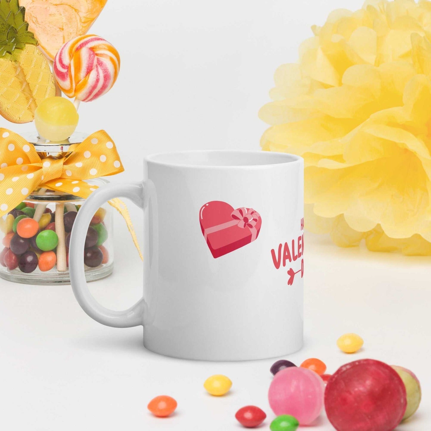 White ceramic valentine mug with heart gift design, styled with colorful candies; festive and gift-ready.