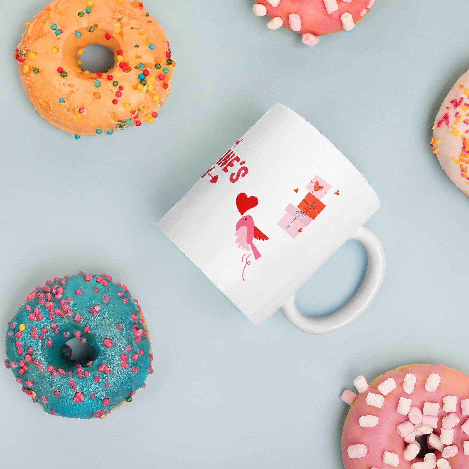 Valentine mug with bird and gift boxes surrounded by colorful donuts. Fun and festive gift idea.