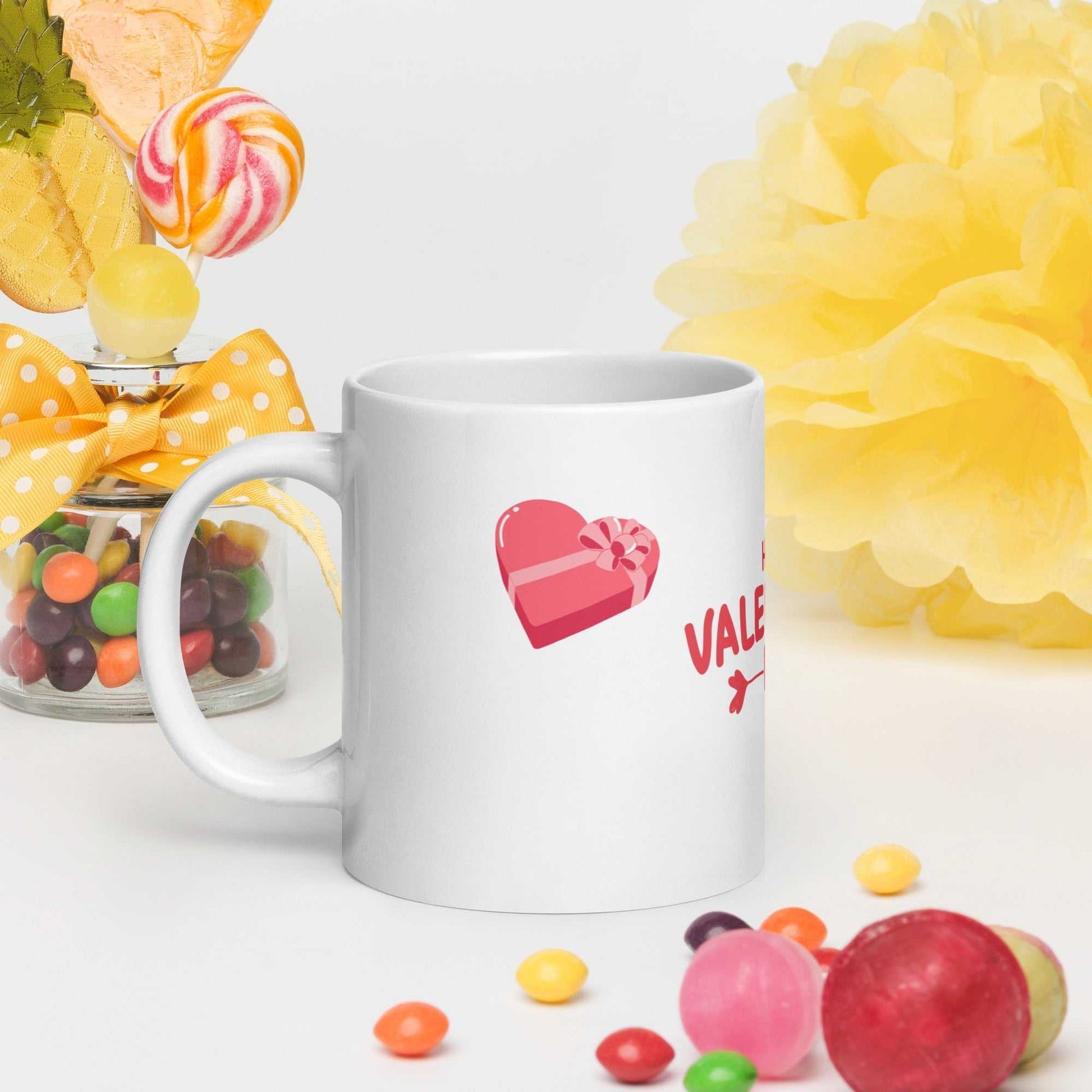 Valentine mug featuring a pink heart with a gift box illustration. Durable ceramic drinkware perfect for romantic gifting occasions.