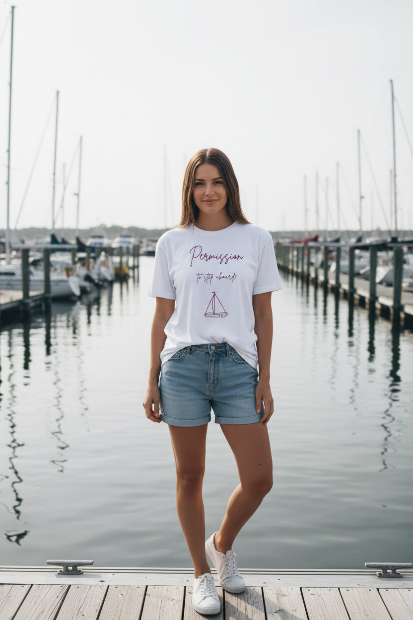 White t-shirt with pink sailboat graphic and text on a white background