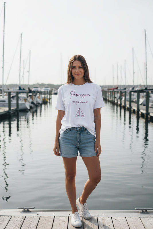 White t-shirt with pink sailboat graphic and text on a white background